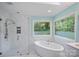Stylish bathroom with a soaking tub, glass-enclosed shower, and serene views at 188 Stonemarker Rd, Mooresville, NC 28117