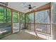 Relaxing screened porch with wood flooring, ceiling fan, and views of the surrounding greenery at 188 Stonemarker Rd, Mooresville, NC 28117