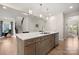 This is a kitchen island with a sink, complemented by modern pendant lighting for a stylish, functional space at 1918 Thoreau Way, York, SC 29745