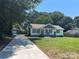 Charming one-story home featuring a long driveway, lush green lawn, and classic architectural details at 203 Blanche Ave, Belmont, NC 28012