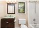 Functional bathroom with a dark wood vanity, a tiled shower-tub, and a bright window view at 216 S Clarkson St # E, Charlotte, NC 28202
