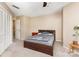 A cozy bedroom featuring neutral walls, carpet, and a wood-framed bed with a ceiling fan at 216 S Clarkson St # E, Charlotte, NC 28202