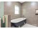 Elegant bathroom featuring a clawfoot tub, tiled walls and a bright window at 219 Lee St, Fort Mill, SC 29715