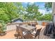Outdoor living on a wood deck complete with dining table and grill, surrounded by mature trees at 219 Lee St, Fort Mill, SC 29715