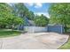 Charming blue home with a long driveway leading to a detached shed and fenced yard at 219 Lee St, Fort Mill, SC 29715