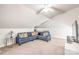 Well-lit attic living room with neutral carpet and comfortable blue sectional at 219 Lee St, Fort Mill, SC 29715
