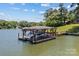 Covered boat dock with boat lift and ample space for watercraft storage, enhancing lakeside living at 230 Shady Cove Rd, Troutman, NC 28166