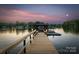 Lake house dock featuring bench seating and boat slip with picturesque views during sunset at 230 Shady Cove Rd, Troutman, NC 28166