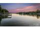 Picturesque waterfront view with a private dock and a vibrant sunset sky, perfect for relaxing and enjoying nature at 230 Shady Cove Rd, Troutman, NC 28166