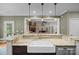 Kitchen island with farmhouse sink and stone countertops overlooks the open-concept living room at 230 Shag Bark Ln, Salisbury, NC 28146