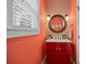 Colorful powder room with a red vanity, decorative mirror, and stylish lighting at 230 Shag Bark Ln, Salisbury, NC 28146
