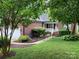 Charming brick home with well-maintained landscaping, a white porch and black fence at 2339 Wednesbury Ct, Kannapolis, NC 28083