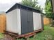 A backyard storage shed with gray siding and black doors offers a practical outdoor solution at 2339 Wednesbury Ct, Kannapolis, NC 28083