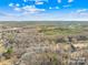 Expansive aerial view of wooded property with a glimpse of a neighborhood, showcasing its tranquil setting at 242 Delview Dr, Cherryville, NC 28021