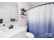 Well-lit bathroom featuring a sleek white sink, modern fixtures, and a stylish shower curtain at 242 Delview Dr, Cherryville, NC 28021