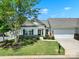 Charming single-story home with a well-manicured front yard, lush landscaping, and an attached two-car garage at 28129 Song Sparrow Ln, Fort Mill, SC 29707