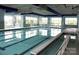 Bright indoor pool area with clear blue water, large windows, and a spa at 28129 Song Sparrow Ln, Fort Mill, SC 29707