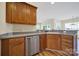 This kitchen features brown cabinets, stainless steel appliances, and a sink overlooking the backyard at 28129 Song Sparrow Ln, Fort Mill, SC 29707
