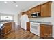 Bright kitchen featuring wood cabinets, white appliances, and vinyl floors at 28129 Song Sparrow Ln, Fort Mill, SC 29707