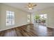 Bright living room with wood floors, ceiling fan, and sliding glass doors to the balcony at 28129 Song Sparrow Ln, Fort Mill, SC 29707