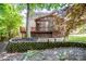 A spacious backyard featuring a screened-in porch, wooden deck, and brick retaining wall at 292 Rose St, Mooresville, NC 28117
