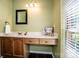 Bathroom vanity featuring wood cabinets, drawers, marble countertop, framed mirror and a three-light vanity fixture at 292 Rose St, Mooresville, NC 28117