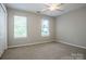 A bedroom with neutral walls and carpeting, featuring windows providing natural light at 292 Rose St, Mooresville, NC 28117
