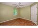 This bedroom features hardwood floors, a ceiling fan, and a window that provides natural light at 292 Rose St, Mooresville, NC 28117
