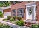 Up-close view of front door framed by black shutters, tasteful landscaping, and brick facade at 292 Rose St, Mooresville, NC 28117