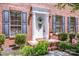 Up-close view of front door framed by black shutters, tasteful landscaping, and brick facade at 292 Rose St, Mooresville, NC 28117