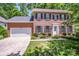 Beautiful two-story brick home featuring manicured landscaping, a white front door, and black shutters at 292 Rose St, Mooresville, NC 28117