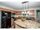 Kitchen with stainless steel appliances, granite counters, wood cabinets, pendant lighting and kitchen island at 292 Rose St, Mooresville, NC 28117