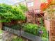 Fenced backyard features mature trees, manicured garden beds, and a patio at 3044 Luke Crossing Dr, Charlotte, NC 28226