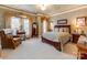 Spacious bedroom with a sitting area, rich wood furniture, neutral walls, and carpeted floors at 3044 Luke Crossing Dr, Charlotte, NC 28226