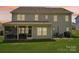 View of the home's back exterior, complete with a screened porch and outdoor dining area on a green lawn at 3218 Gilroy Dr, Fort Mill, SC 29707