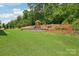 Spacious backyard features a playset and tiered garden beds on a lush lawn at 3218 Gilroy Dr, Fort Mill, SC 29707