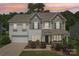 Charming two-story home with a well-manicured lawn and welcoming front porch at sunset at 3218 Gilroy Dr, Fort Mill, SC 29707