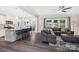 Open-concept living room with kitchen island, gray sofa, and natural lighting at 3218 Gilroy Dr, Fort Mill, SC 29707