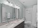 Bright bathroom features double vanity sinks, modern fixtures, and a shower with tiled walls at 3524 Rhett Butler Pl, Charlotte, NC 28270