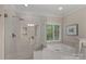 Elegant bathroom featuring a glass enclosed shower, separate tub, vanity, and shuttered window at 3524 Rhett Butler Pl, Charlotte, NC 28270