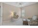 Cozy bedroom features neutral walls, carpet, vanity with a mirror, chair, and a shuttered window at 3524 Rhett Butler Pl, Charlotte, NC 28270