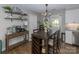 Farmhouse dining area with wooden table, modern lighting and open shelving at 386 Greenlea Cir, Taylorsville, NC 28681