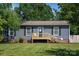 Charming single-story home showcasing a welcoming front porch, fresh exterior paint, and lush green lawn at 386 Greenlea Cir, Taylorsville, NC 28681