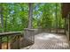 Spacious wooden deck with natural wood railings and steps leading to a lush, tree-filled backyard at 392 Tall Oaks Trl, Fort Mill, SC 29715