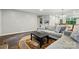 Open living room boasts dark wood floors, a patterned accent rug, and a view to the kitchen and dining area at 392 Tall Oaks Trl, Fort Mill, SC 29715