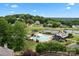Overhead view of community amenities, including a pool, clubhouse, tennis courts, playground and surrounding homes at 400 Maymont Dr, Cramerton, NC 28032
