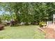 Manicured backyard featuring mature trees, lush lawn, and bird bath at 400 Maymont Dr, Cramerton, NC 28032