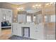 Bathroom featuring double sinks, white cabinetry, elegant wallpaper, and an entrance into the bedroom at 400 Maymont Dr, Cramerton, NC 28032