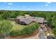 Exterior view of the community clubhouse surrounded by mature trees and manicured landscaping at 400 Maymont Dr, Cramerton, NC 28032