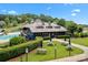 Community clubhouse featuring a pool, playground, picnic tables, and lush landscaping for outdoor enjoyment at 400 Maymont Dr, Cramerton, NC 28032